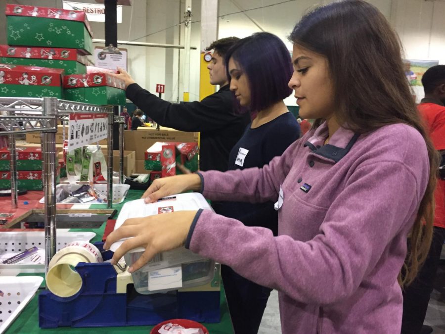 Packaging more gift boxes, seniors Eliana Castro and Adia Diaz and freshman Keagan Wright prepare toy boxes for kids in need through Operation Christmas Child. 