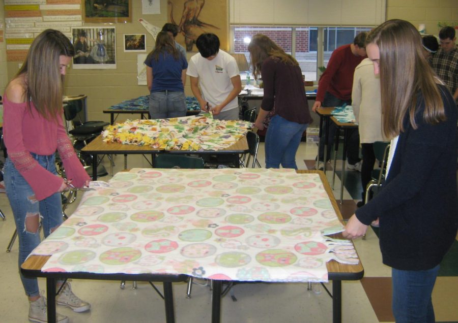 Tying the ends of a blanket together, junior
Anna Cottrell finishes one project of many as a part of the new charity event.